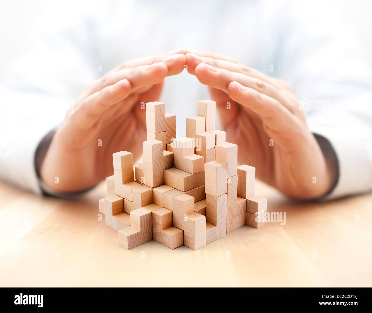 Sicurezza business development concept. Blocchi di legno coperto da mani. Foto Stock