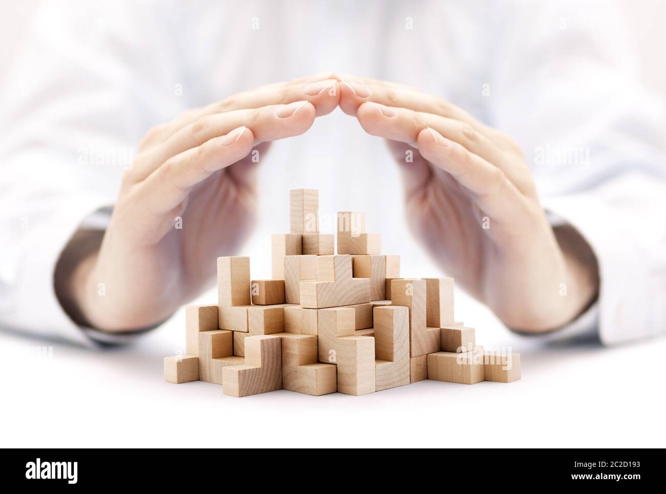 Sicurezza business development concept. Blocchi di legno coperto da mani. Foto Stock