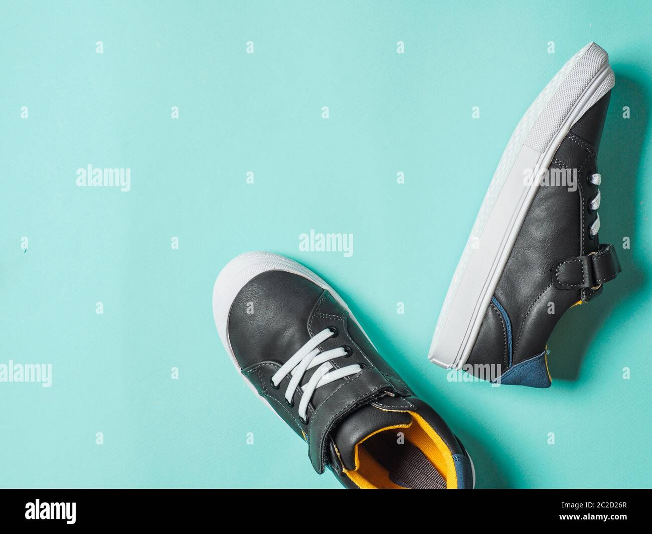Sneaker grigie e gialle su sfondo blu Foto Stock