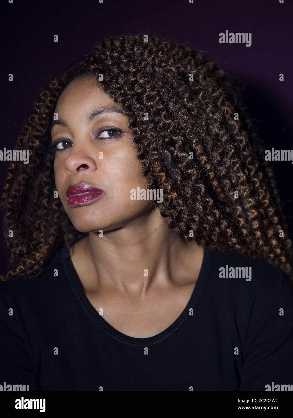 Ritratto verticale di una donna afro-americana che guarda la fotocamera Foto Stock