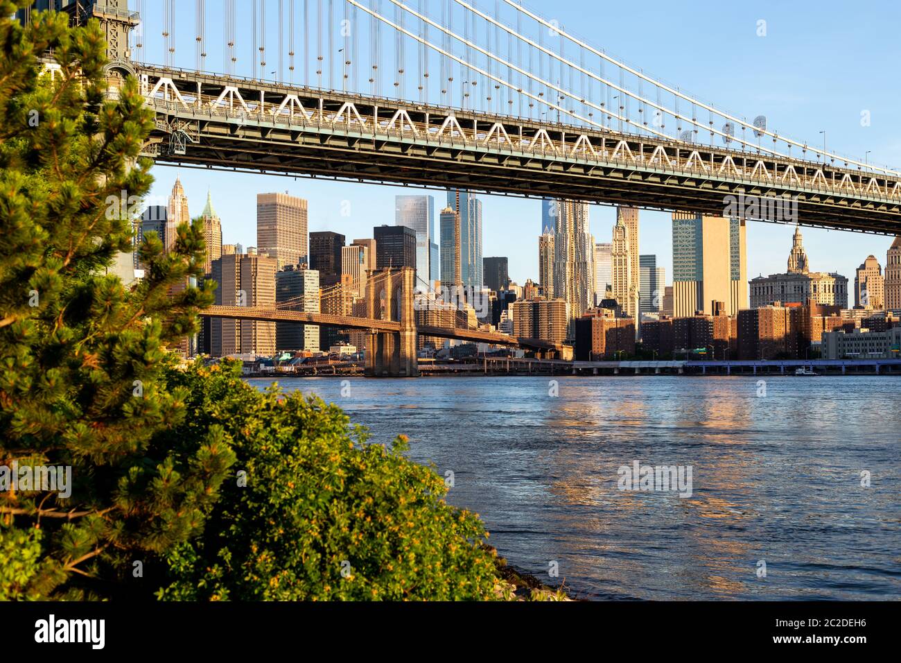 La città di New York / STATI UNITI D'America - 25 GIU 2018: Ponte di Brooklyn Park con la parte inferiore di Manhattan skyline di sunrise Foto Stock