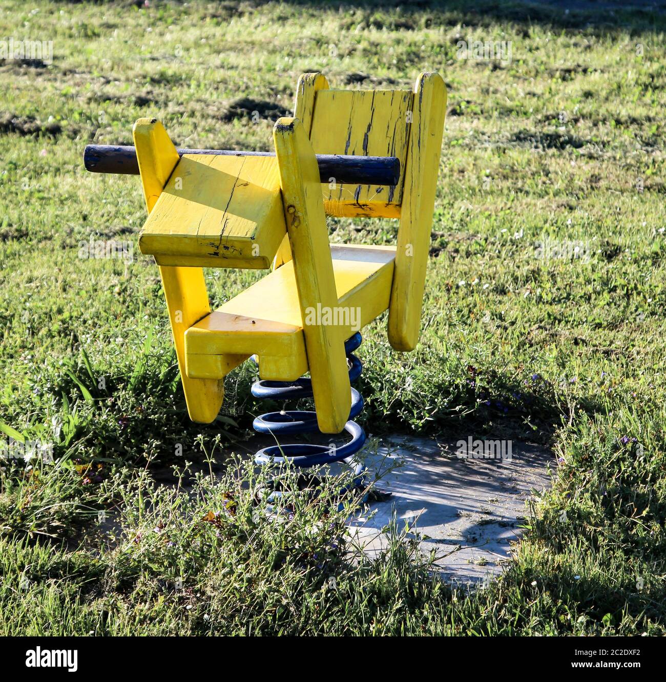 un cavallo giallo a dondolo per i bambini in un parco giochi Foto Stock