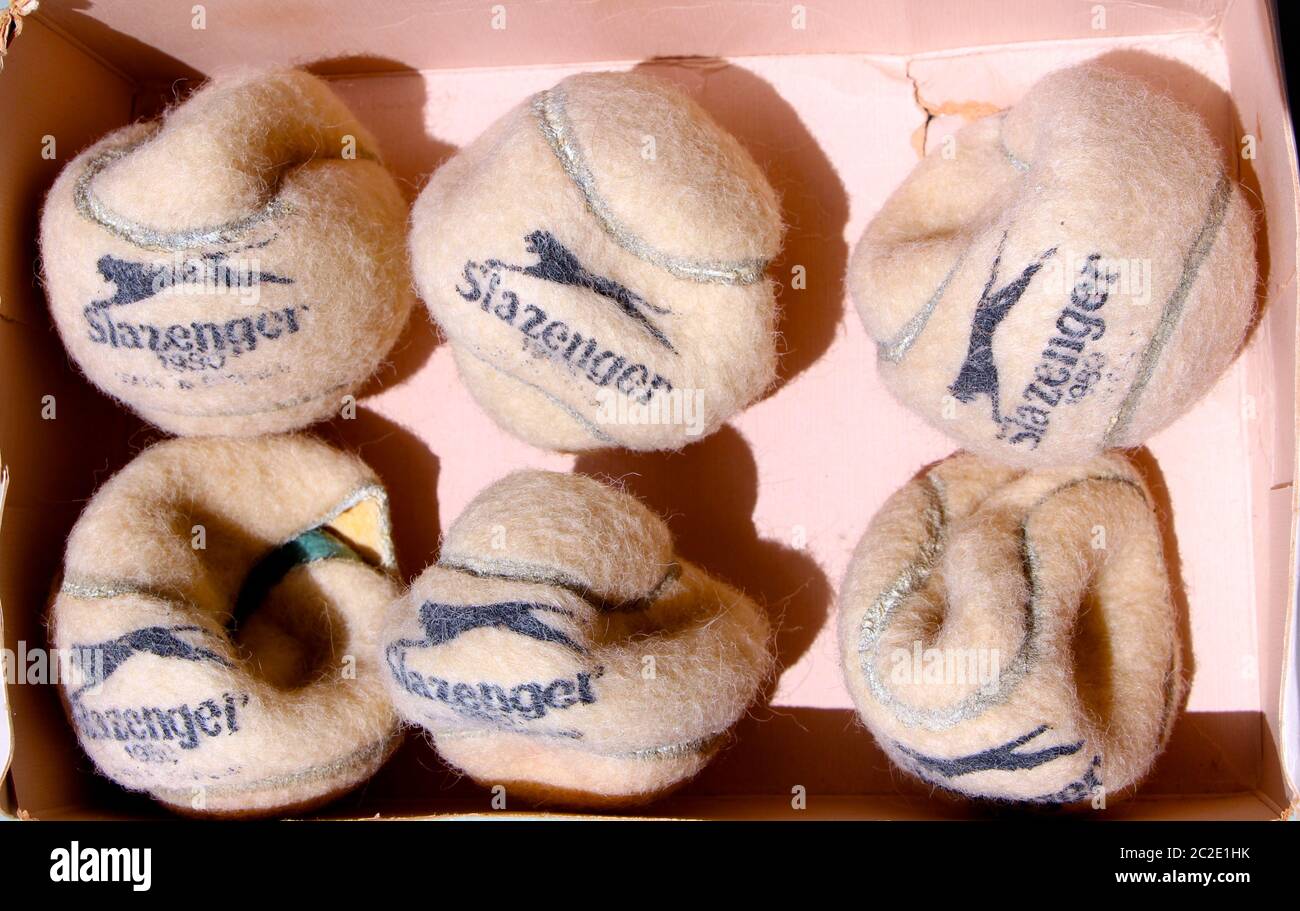Sei vecchie palle da tennis Slazenger distrutte in una scatola con il coperchio aperto Foto Stock