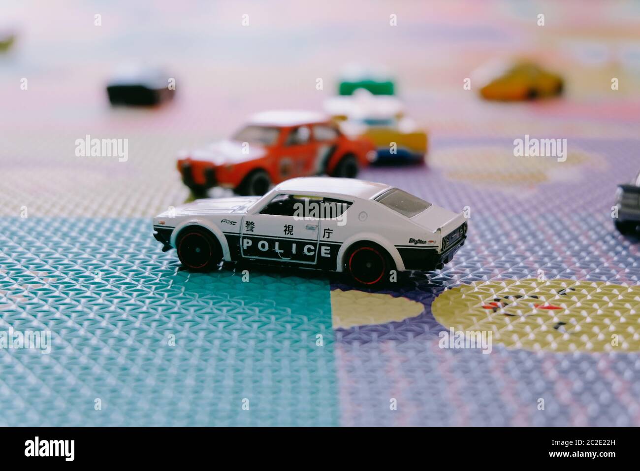 Giocattoli colorati piccoli Hot Wheels automobili di Mattel in stanza dei bambini tappetino di gioco Foto Stock