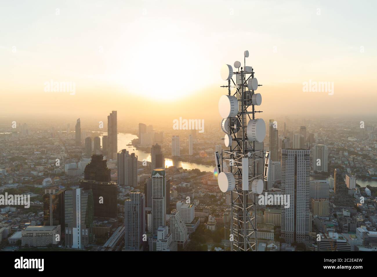 Torre di telecomunicazione con antenna di rete cellulare 5G su sfondo urbano Foto Stock