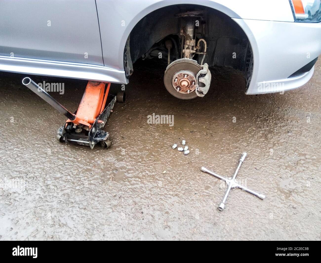 La vettura è al pneumatico negozio. Sotto il martinetto di auto in auto-centro di cura. La vettura con la ruota rimossa Foto Stock
