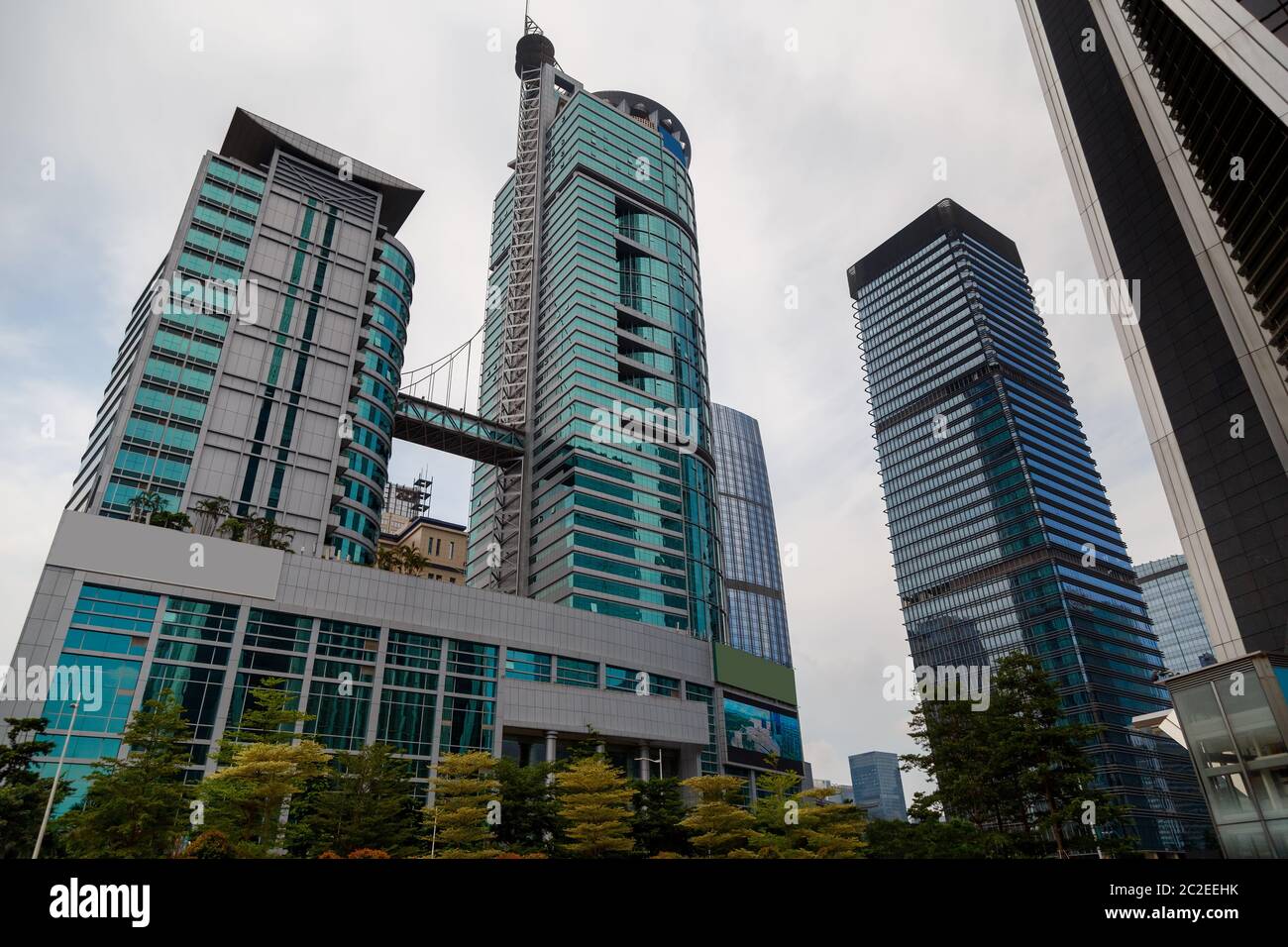 Grattacieli in una metropoli ad un angolo acuto contro un cielo nuvoloso, quartiere degli affari nel centro della città, Shenzhen, Cina Foto Stock
