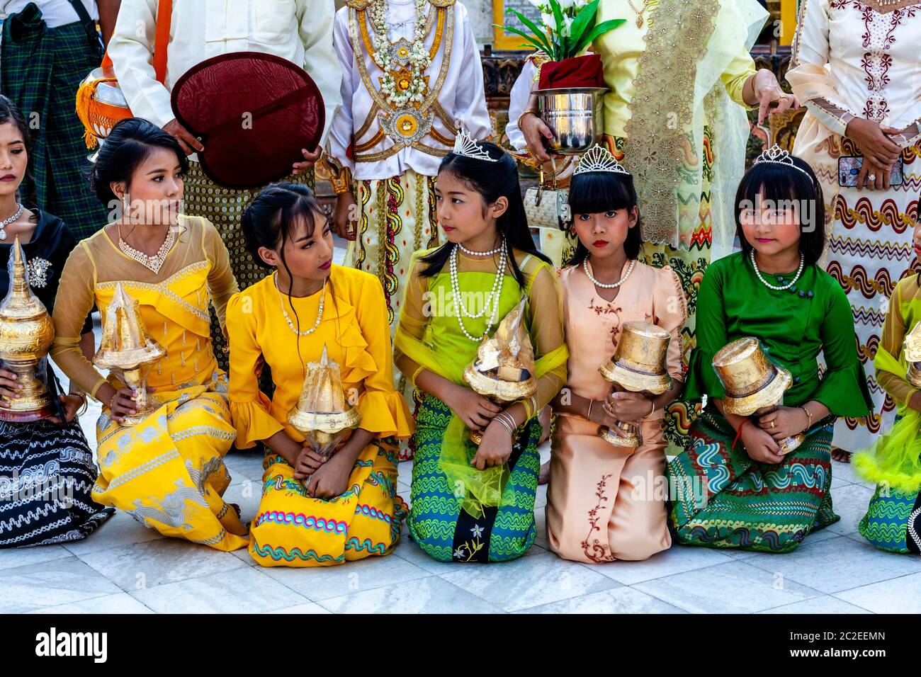 I bambini vestiti con colori prendono parte AD UNA cerimonia di noviziazione/Shinbyu alla pagoda di Shwedagon, Yangon, Myanmar. Foto Stock