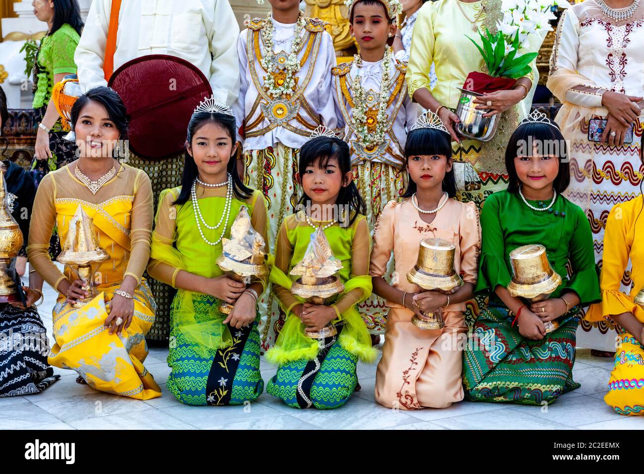 I bambini vestiti con colori prendono parte AD UNA cerimonia di noviziazione/Shinbyu alla pagoda di Shwedagon, Yangon, Myanmar. Foto Stock