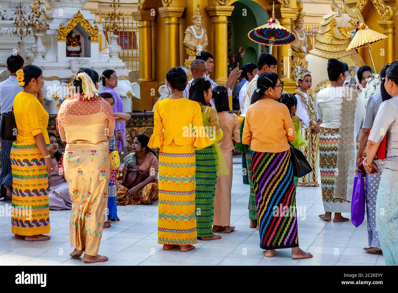 La gente locale guarda UNA cerimonia di Noviziazione/Shinbyu alla Pagoda Shwedagon, Yangon, Myanmar. Foto Stock