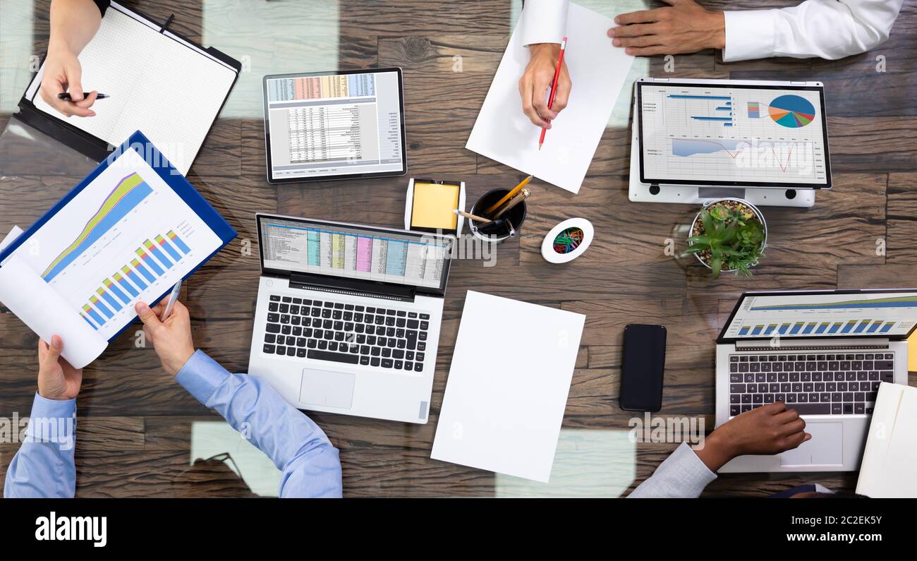 Elevato angolo di visione di un team di dirigenti aziendali discutendo sui dati in Sala Riunioni Foto Stock