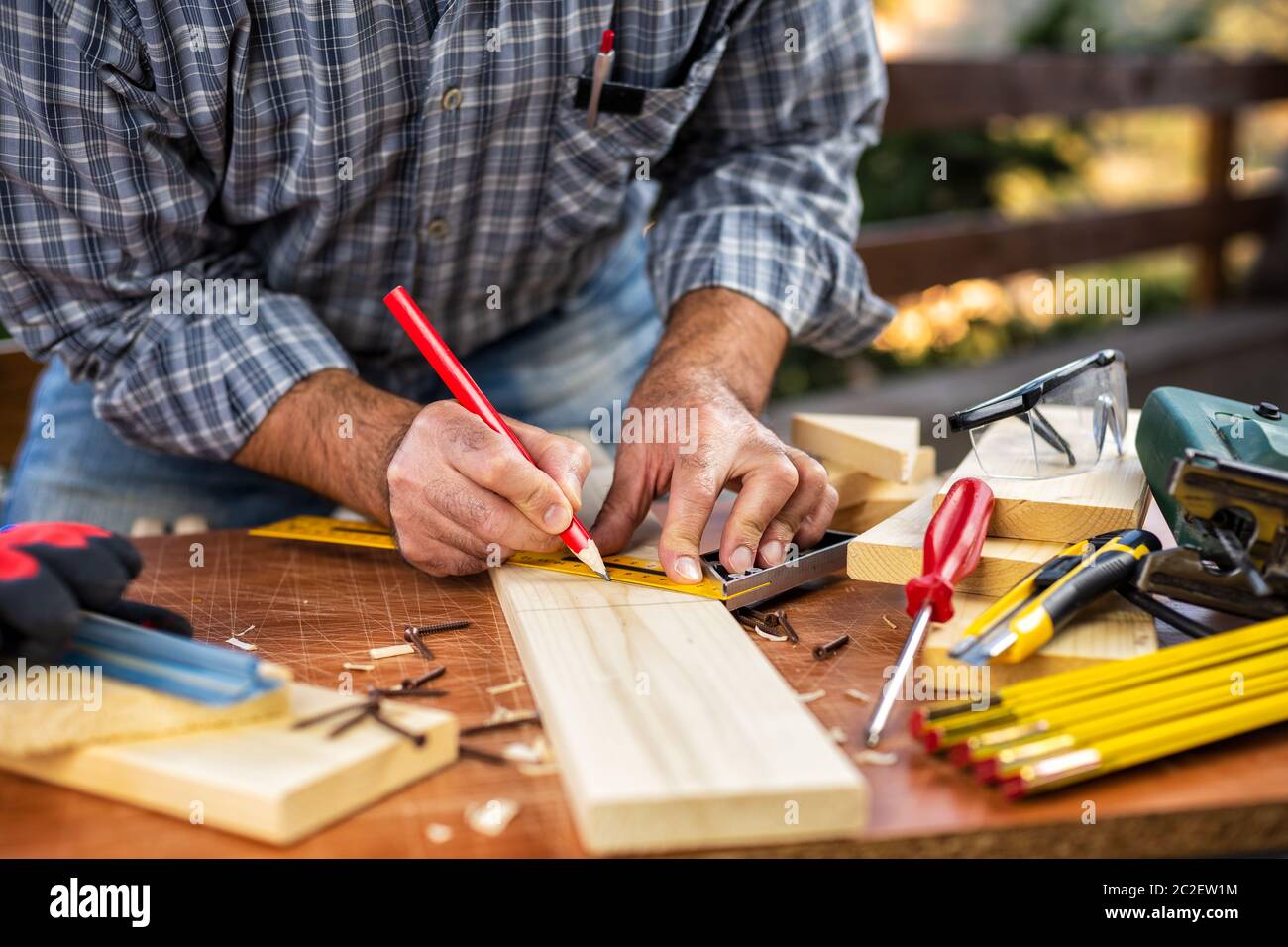 Artigiano carpentiere per adulti con una matita e del falegname team tracciare la linea di taglio su un tavolo di legno. Lavori domestici fai da te. Fotografia stock. Foto Stock