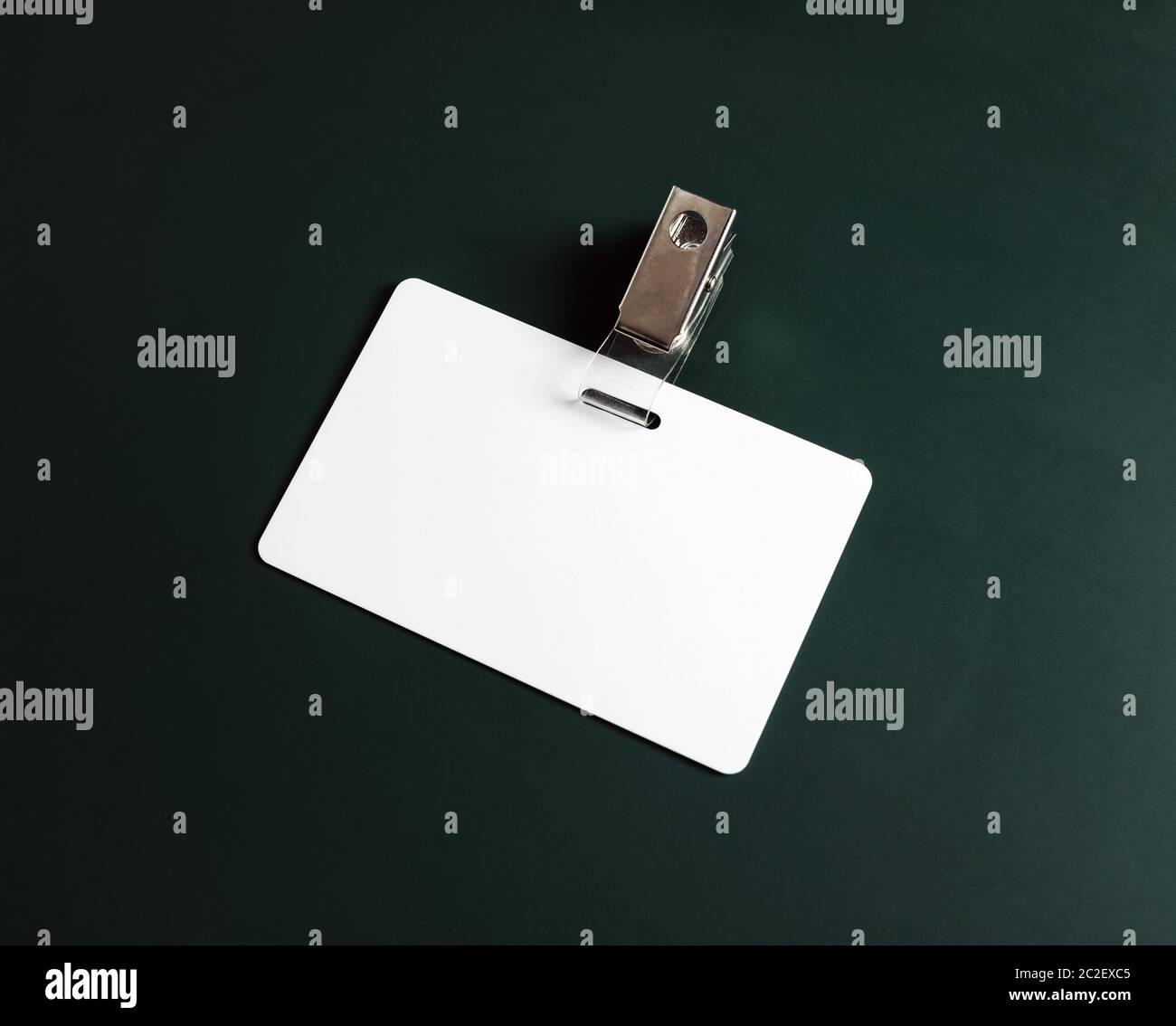 White ID card. Vuoto badge di sicurezza sulla lavagna verde dello sfondo. Copia spazio per il testo. Foto Stock