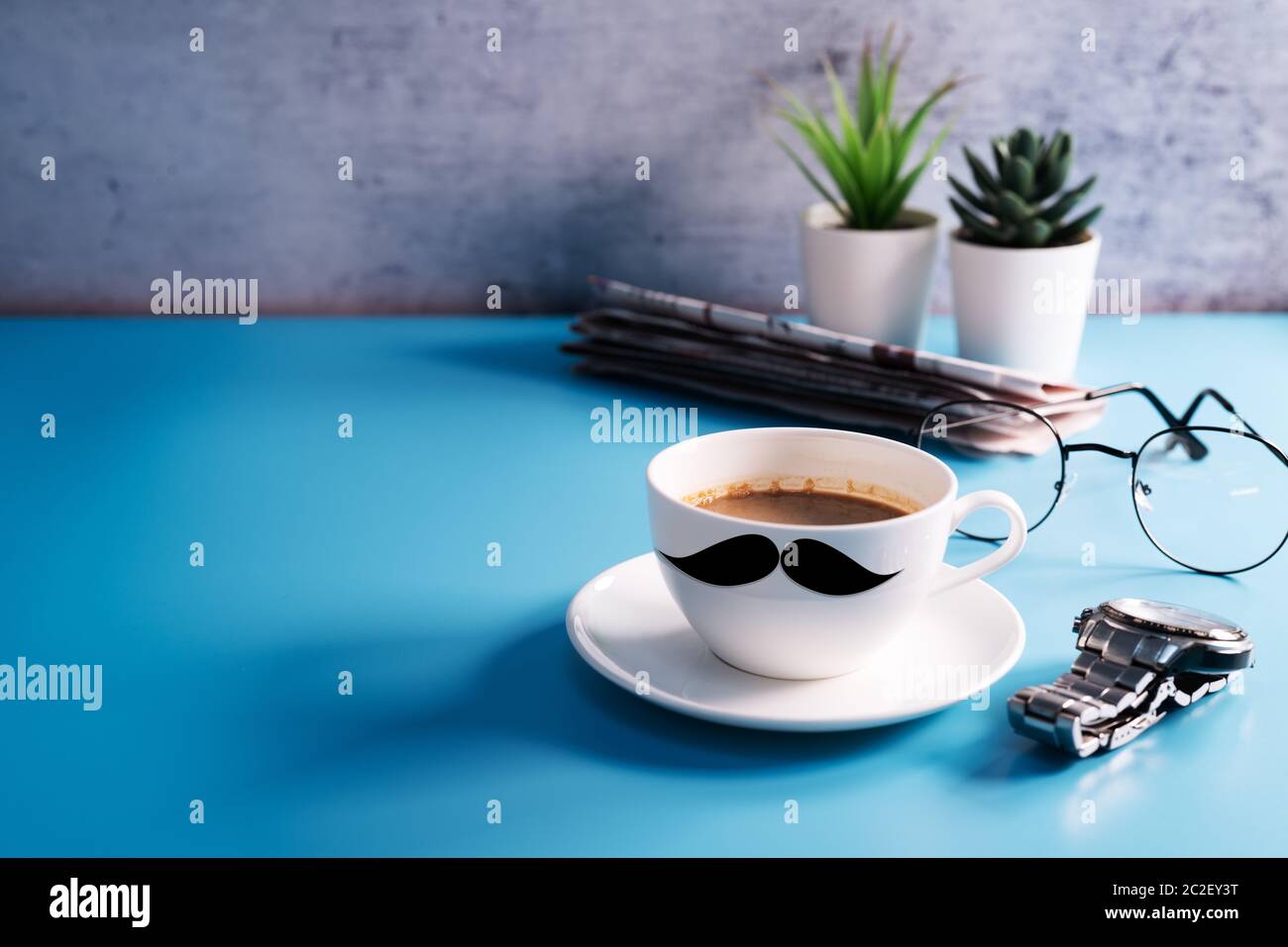 Happy Feathers Day, una tazza di caffè con occhiali e giornali Foto Stock