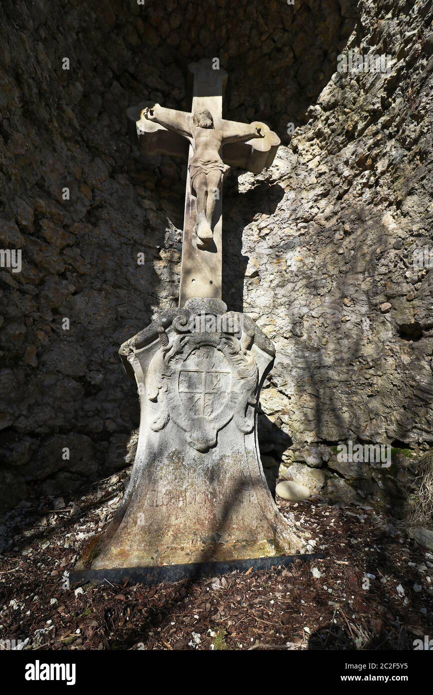 Una croce di pietra in una grotta. Una vecchia croce di pietra per i pellegrini. Foto Stock