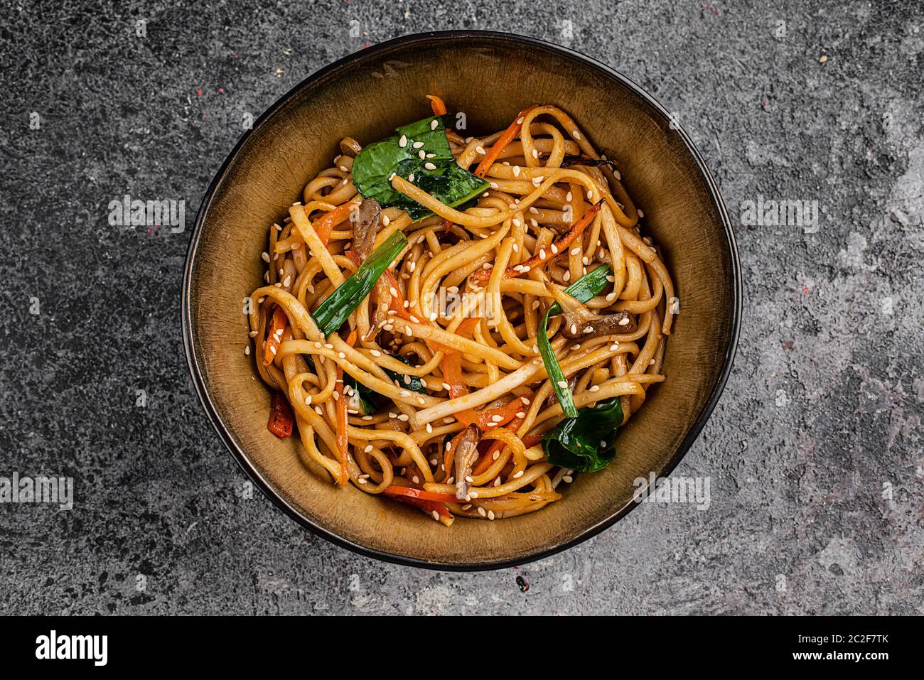 Fried Soba Noodles con funghi, broccoli, carote, peperoni closeup su una piastra su un tavolo. Verticale in alto vista da sopra Foto Stock