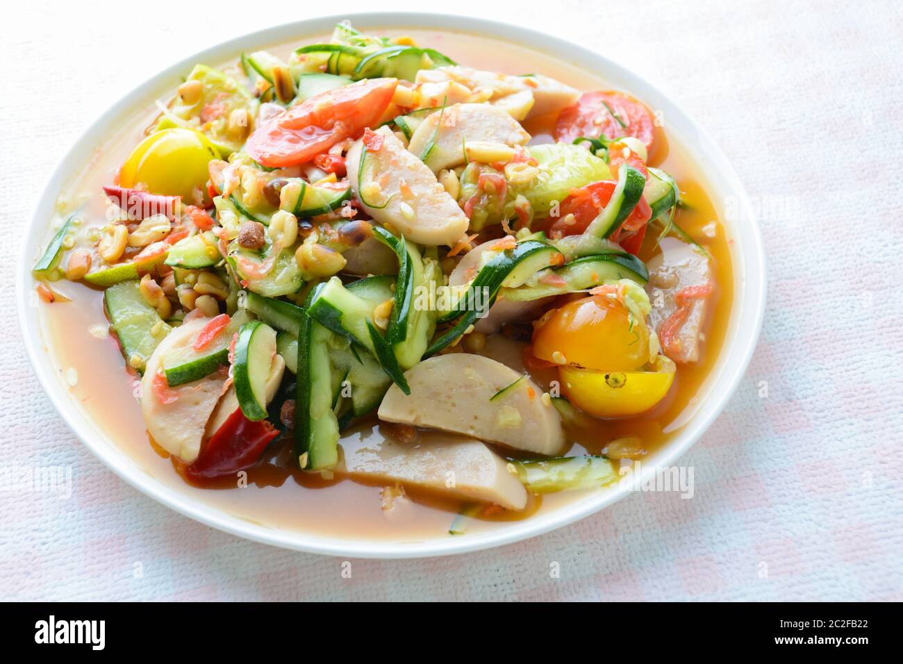 Insalata di cetrioli con salsicce di maiale conservate, cibo tailandese popolare chiamato Som Tum Tang, verdure calde e piccanti, miste. Foto Stock