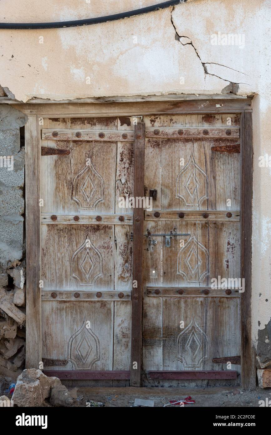 Porta di legno marrone intemperie nella città di al Ayjah vicino a sur, Oman Foto Stock