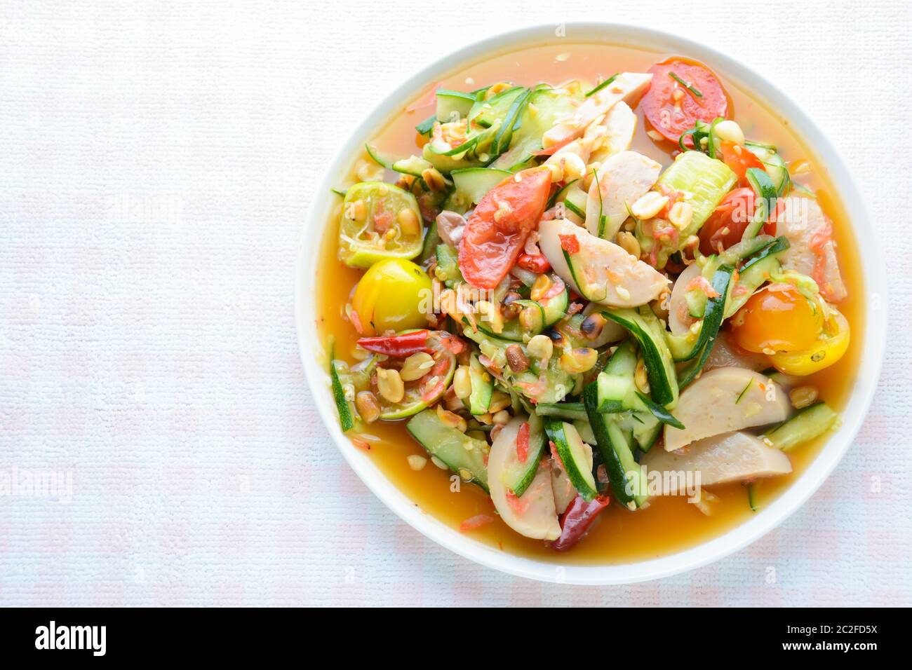 Insalata di cetrioli con salsicce di maiale conservate, cibo tailandese popolare chiamato Som Tum Tang, verdure calde e piccanti, miste. Foto Stock