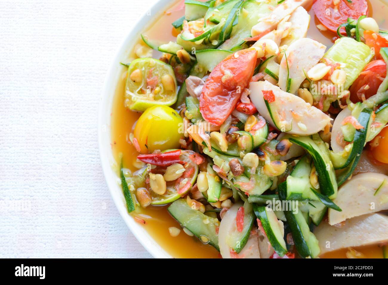 Insalata di cetrioli con salsicce di maiale conservate, cibo tailandese popolare chiamato Som Tum Tang, verdure calde e piccanti, miste. Foto Stock