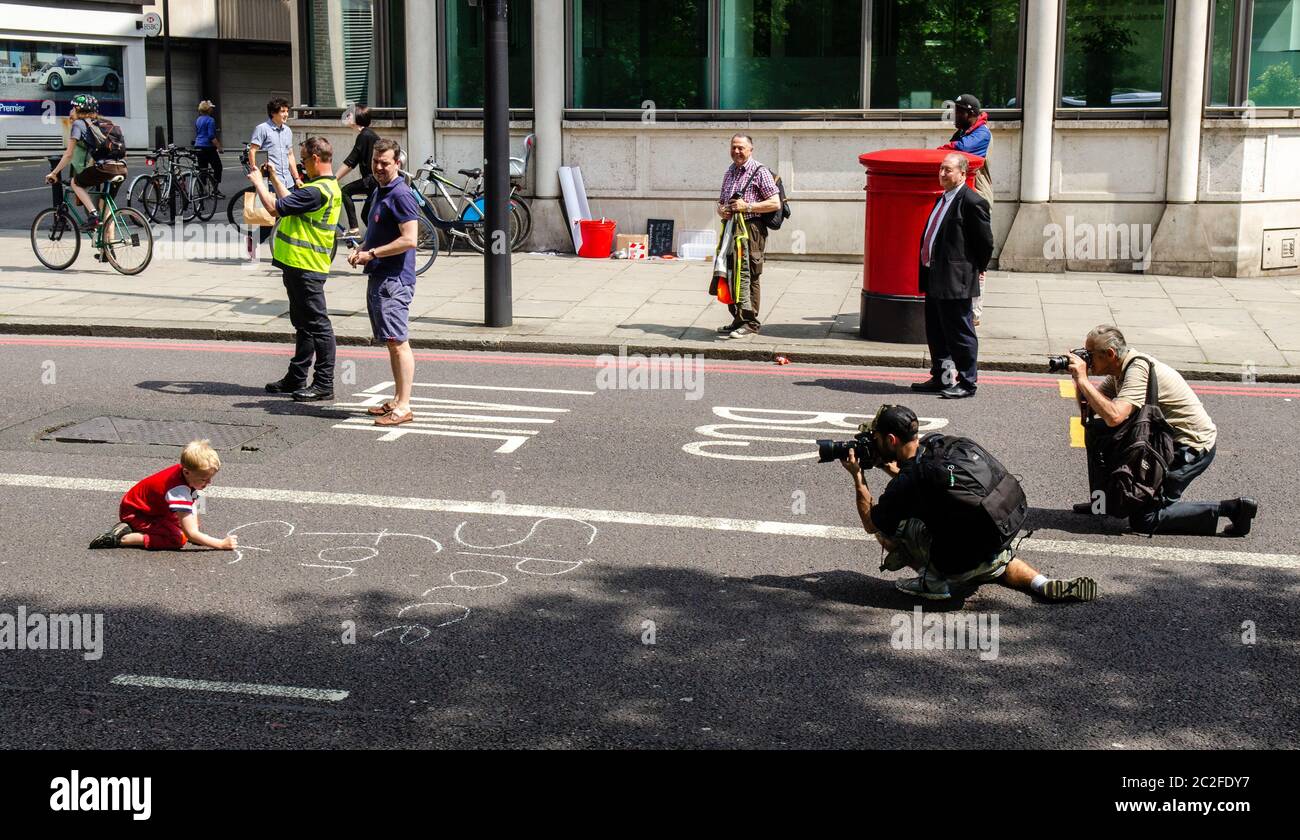 Londra, Inghilterra, Regno Unito - 17 maggio 2014: Un bambino scrive slogan su una strada come parte di una strada di protesta attraverso il centro di Londra come parte del London Cycling Foto Stock