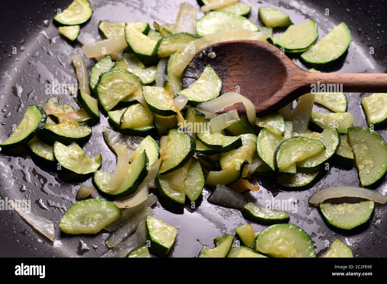 Cottura delle zucchine con cipolla in padella Foto Stock