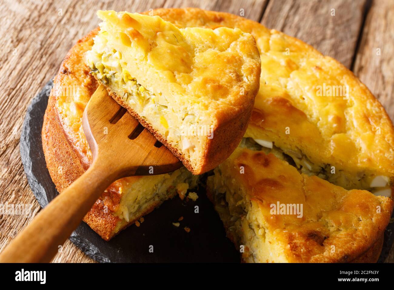 Torta di cavolo al forno con erbe e uova bollite primo piano sul tavolo. Orizzontale Foto Stock