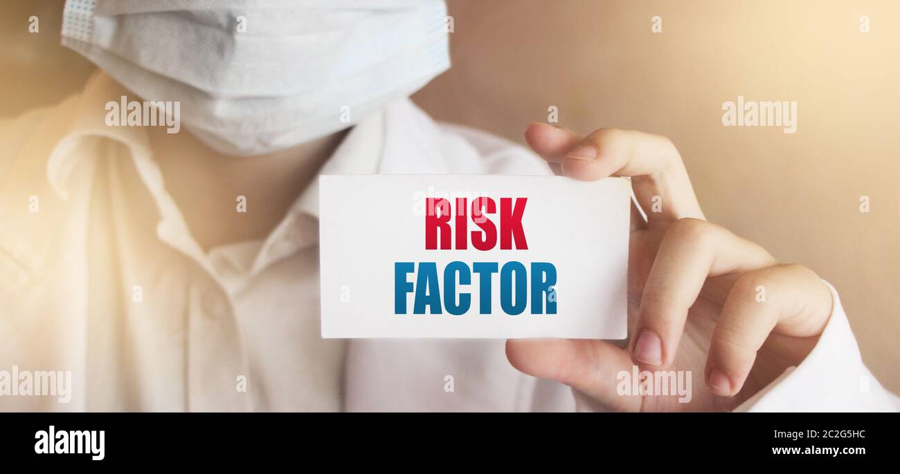 Medico che detiene una carta con il concetto medico del fattore di rischio Foto Stock