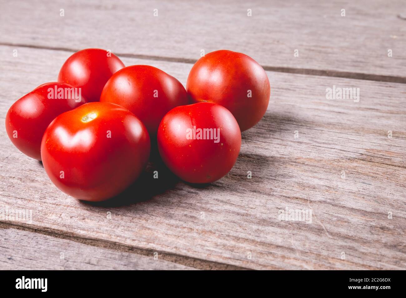 Pomodori maturi su tavola di legno sfondo in studio Foto Stock