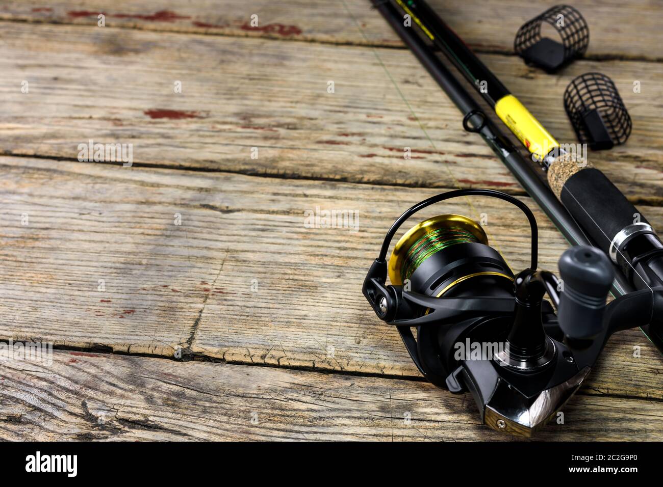 Canna da pesca e attrezzatura da pesca su vecchio sfondo di legno con spazio libero per il testo. Foto Stock