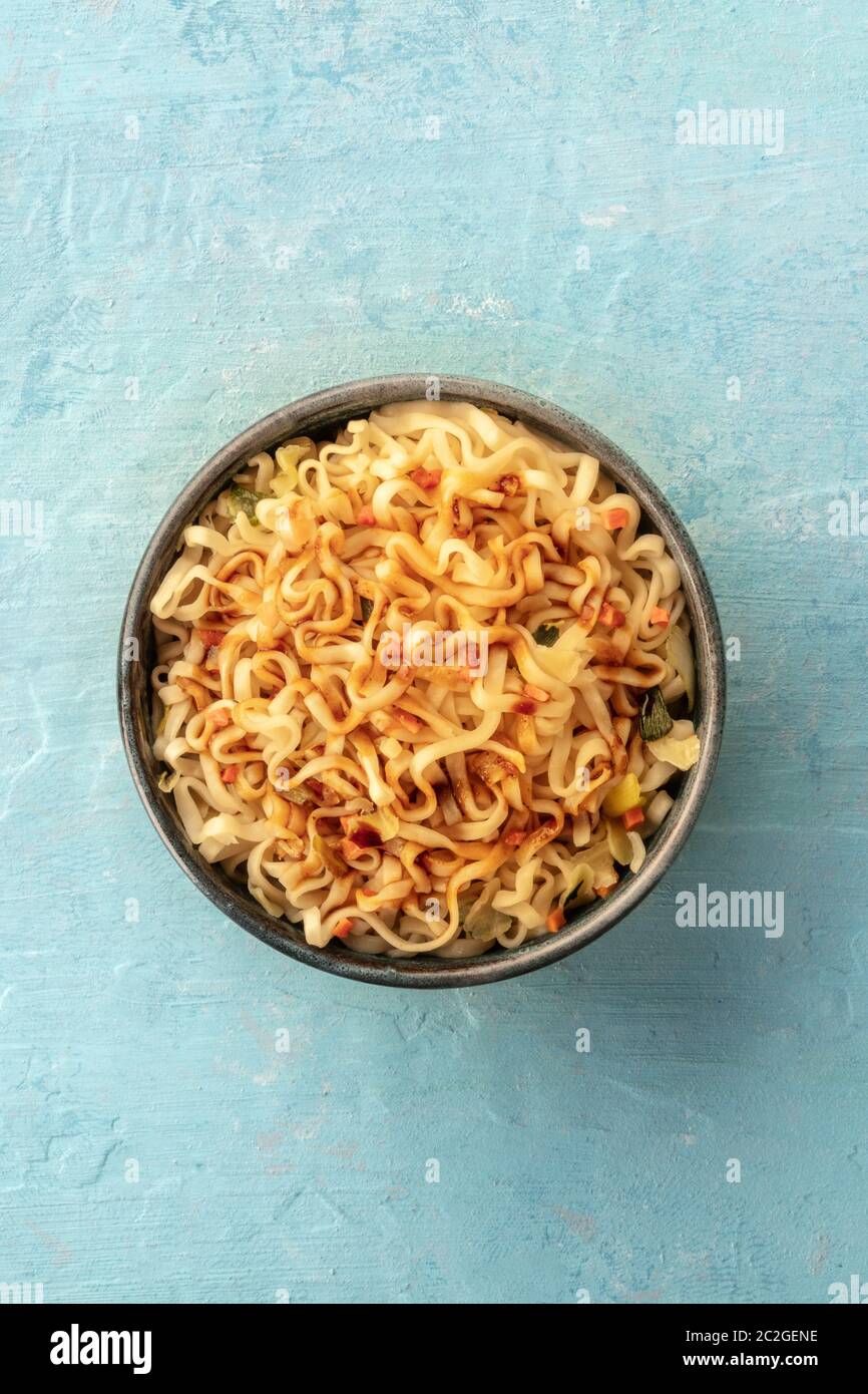 Instant Soba Noodles con la carota e una salsa, overhead shot su un teal sfondo blu con copyspace Foto Stock