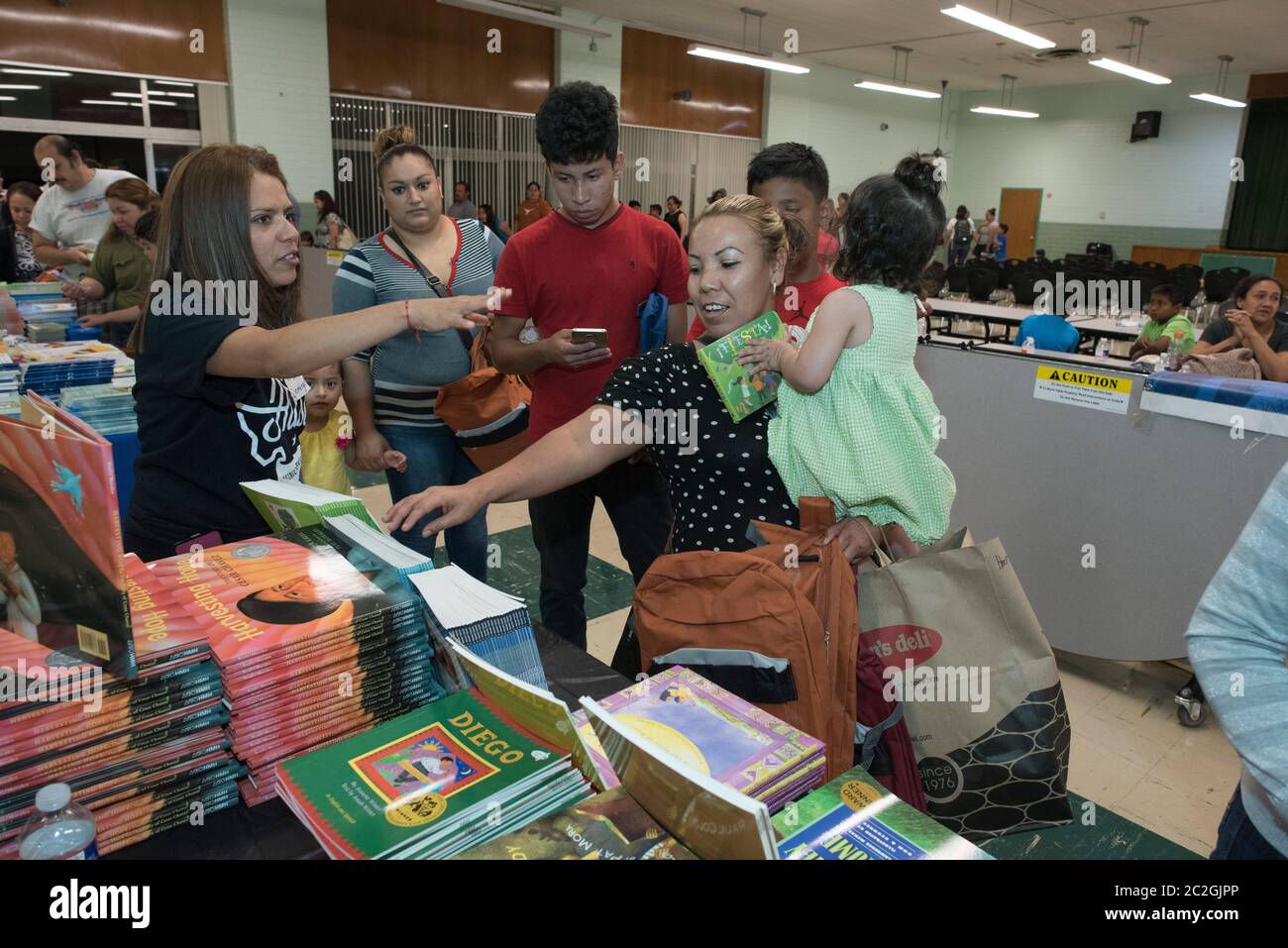 Austin Texas USA, 25 giugno 2016: Colorin Colorado tiene un workshop di sabato per genitori, insegnanti e amministratori di programmi per studenti di lingua inglese (ELL) e ESL. L'organizzazione no-profit offre una ricchezza di informazioni, attività e consigli bilingue e basati sulla ricerca per educatori e famiglie, molte delle quali sono parlanti spagnoli a basso reddito. Questi partecipanti stanno raccogliendo libri di storia gratuiti per bambini. ©Bob Daemmrich Foto Stock