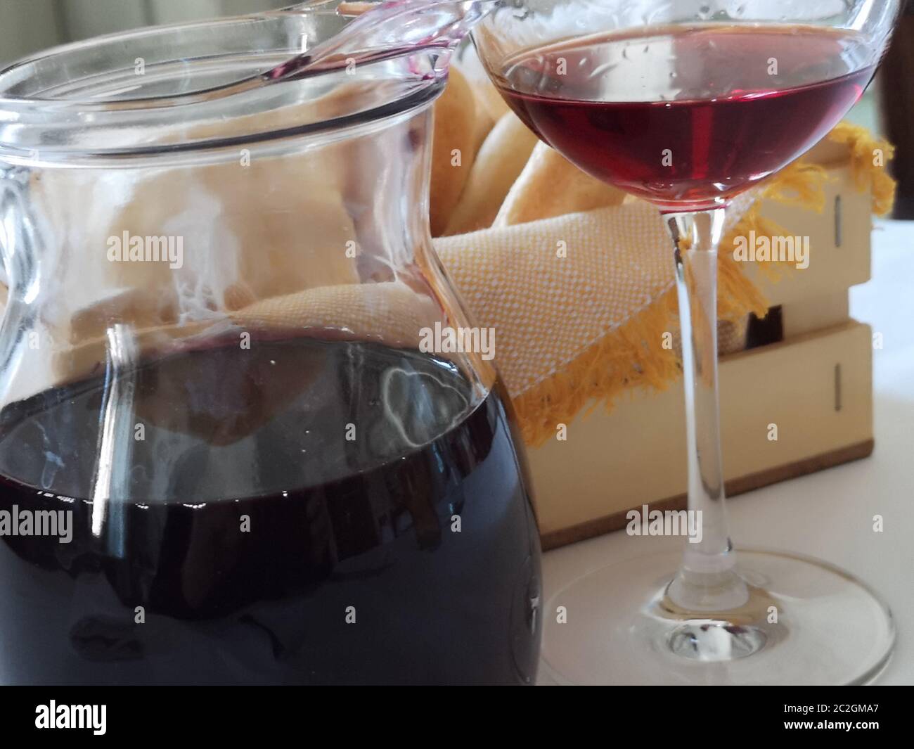 vino rosso in una caraffa e cestino di pane Foto Stock