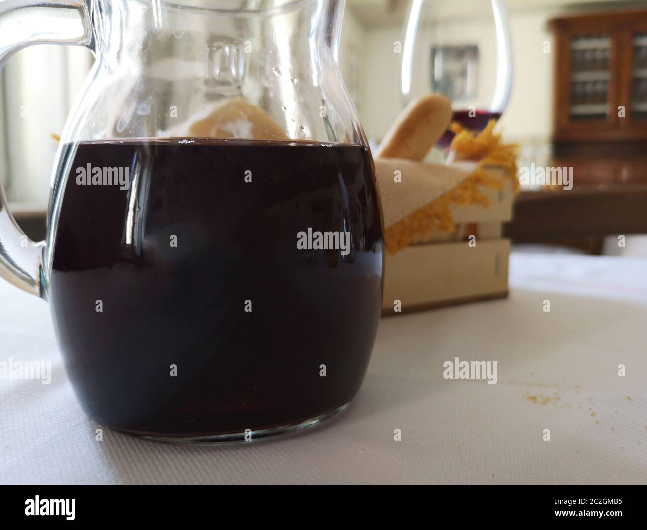 vino rosso in una caraffa e cestino di pane Foto Stock