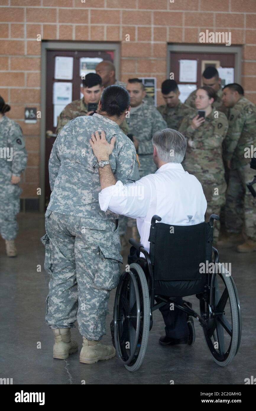 Weslaco, Texas USA, 12 aprile 2018: Texas Gov. Greg Abbott saluta il membro della Guardia Nazionale dell'Esercito in un'armeria della Guardia Nazionale nell'estremo sud del Texas, dove le truppe si stanno preparando per lo schieramento al confine tra Texas e Messico. I soldati avranno un ruolo di sostegno con la pattuglia federale delle frontiere e i soldati statali che tenteranno di combattere l'immigrazione clandestina al confine meridionale degli Stati Uniti. ©Bob Daemmrich Foto Stock