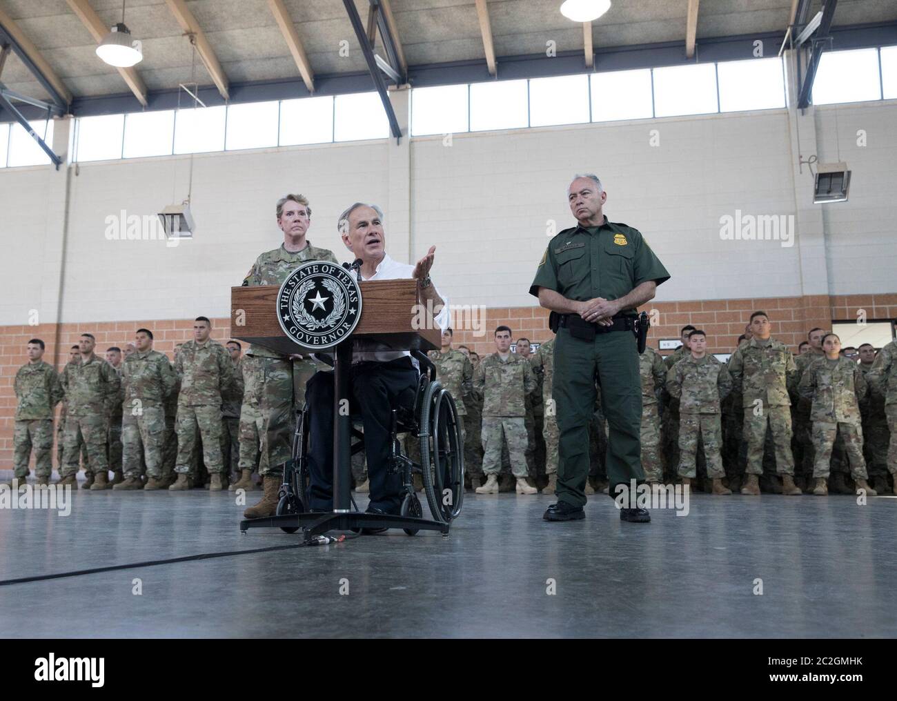 Weslaco, Texas USA, 12 aprile 2018: Texas Gov. Greg Abbott parla con le truppe della Guardia Nazionale presso l'armeria della Guardia Nazionale nell'estremo sud del Texas mentre si preparano per lo schieramento al vicino confine Texas-Messico. I soldati avranno un ruolo di sostegno con la pattuglia federale di frontiera e i soldati statali che tenteranno di arginare l'immigrazione clandestina al confine meridionale degli Stati Uniti. ©Bob Daemmrich Foto Stock