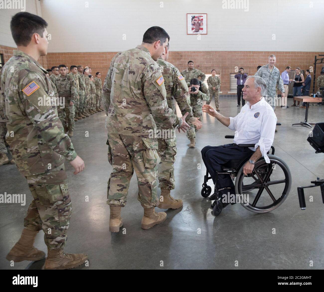Weslaco, Texas USA, 12 aprile 2018: Texas Gov. Greg Abbott saluta il membro della Guardia Nazionale dell'Esercito in un'armeria della Guardia Nazionale nell'estremo sud del Texas, dove le truppe si stanno preparando per lo schieramento al confine tra Texas e Messico. I soldati avranno un ruolo di sostegno con la pattuglia federale delle frontiere e i soldati statali che tenteranno di combattere l'immigrazione clandestina al confine meridionale degli Stati Uniti. ©Bob Daemmrich Foto Stock