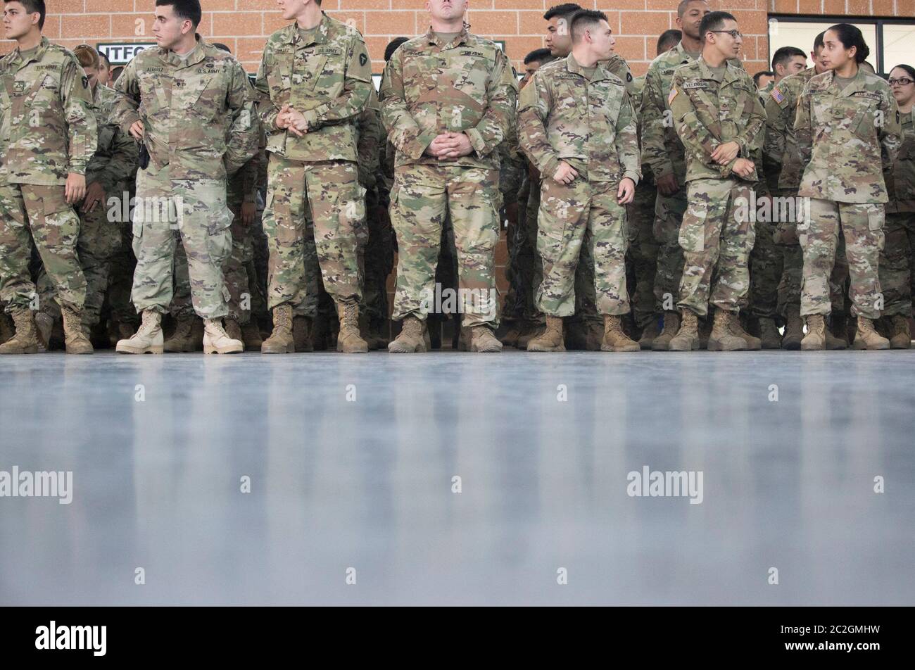 Weslaco, Texas 12 aprile 2018: Le truppe stanno all'attenzione di un'armeria della Guardia Nazionale nell'estremo sud del Texas mentre sentono le parole di incoraggiamento dal governatore Greg Abbott mentre si preparano per lo spiegamento al confine Texas-Messico. I soldati avranno un ruolo di sostegno con la pattuglia federale di frontiera e i soldati statali nel tentativo di rallentare l'immigrazione clandestina al confine meridionale degli Stati Uniti. ©Bob Daemmrich Foto Stock