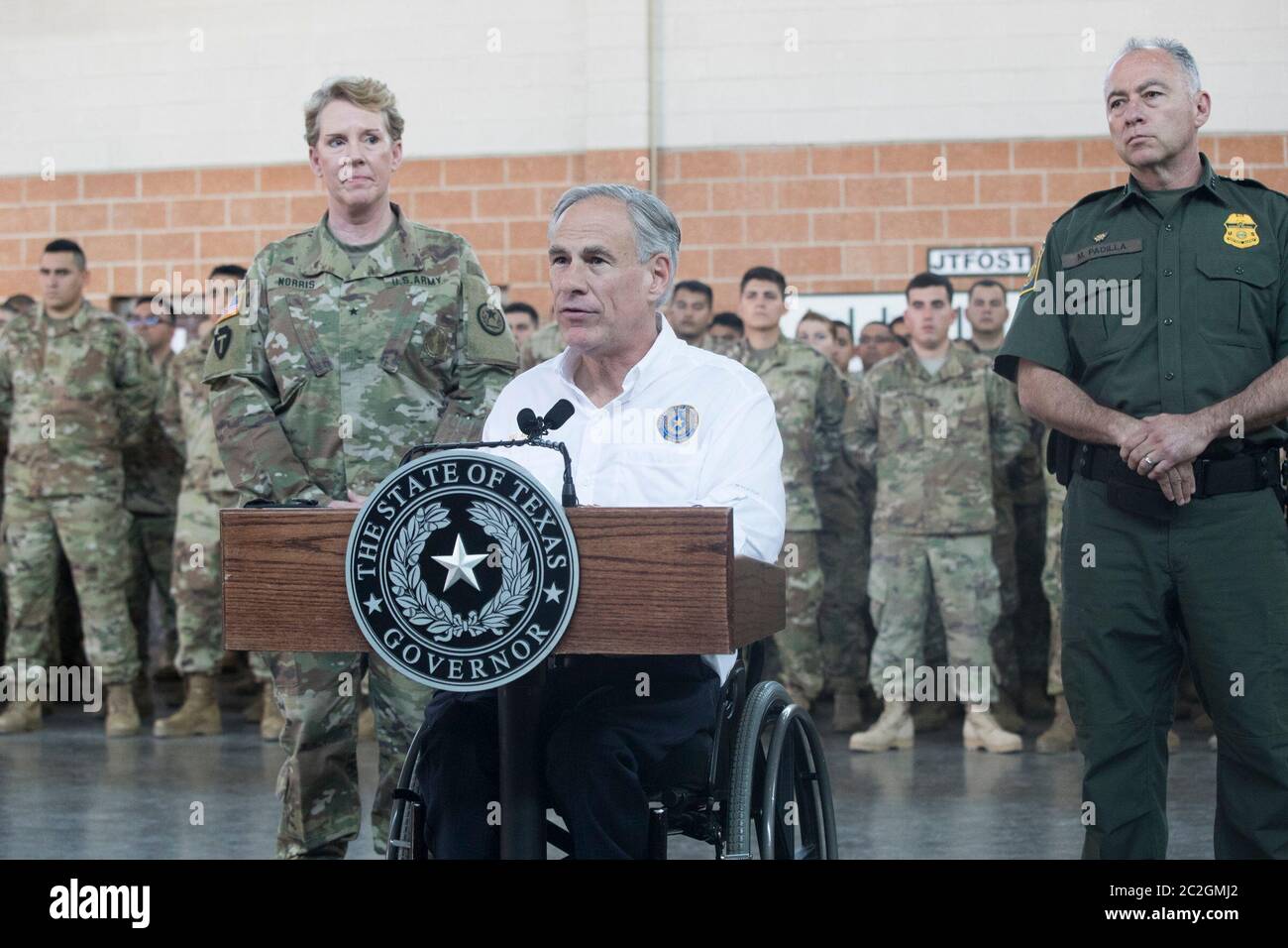 Weslaco, Texas USA, 12 aprile 2018: Texas Gov. Greg Abbott parla con le truppe della Guardia Nazionale presso l'armeria della Guardia Nazionale nell'estremo sud del Texas mentre si preparano per lo schieramento al vicino confine Texas-Messico. I soldati avranno un ruolo di sostegno con la pattuglia federale di frontiera e i soldati statali che tenteranno di arginare l'immigrazione clandestina al confine meridionale degli Stati Uniti. ©Bob Daemmrich Foto Stock