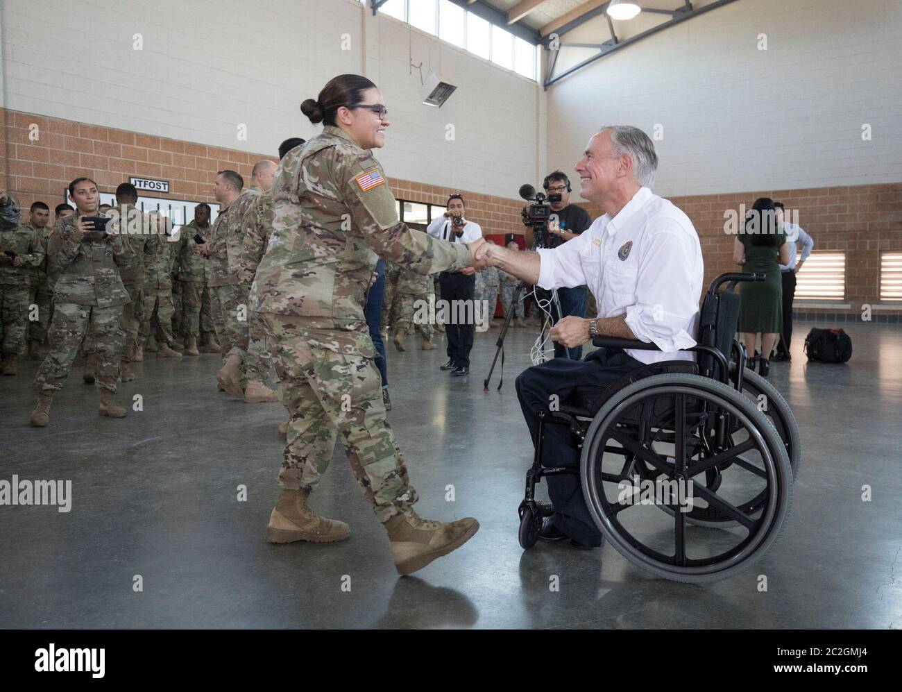 Weslaco, Texas USA, 12 aprile 2018: Texas Gov. Greg Abbott saluta il membro della Guardia Nazionale dell'Esercito in un'armeria della Guardia Nazionale nell'estremo sud del Texas, dove le truppe si stanno preparando per lo schieramento al confine tra Texas e Messico. I soldati avranno un ruolo di sostegno con la pattuglia federale delle frontiere e i soldati statali che tenteranno di combattere l'immigrazione clandestina al confine meridionale degli Stati Uniti. ©Bob Daemmrich Foto Stock