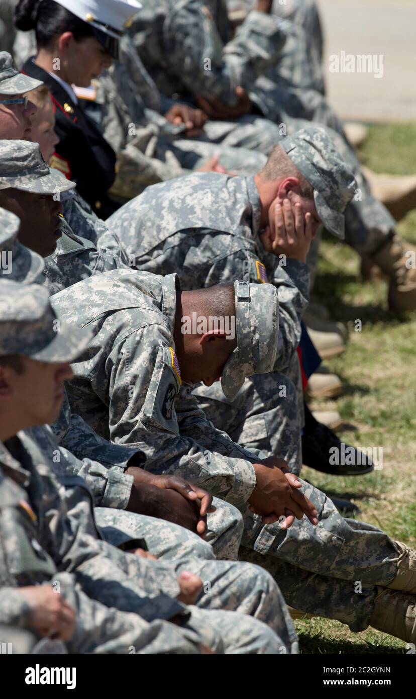 Fort Hood Texas USA, aprile 9 2014: USA I soldati dell'esercito si inchinano la testa durante il discorso del presidente Barack Obama ad un servizio commemorativo per tre soldati di Fort Hood uccisi nel tiro della scorsa settimana. ©Bob Daemmrich Foto Stock