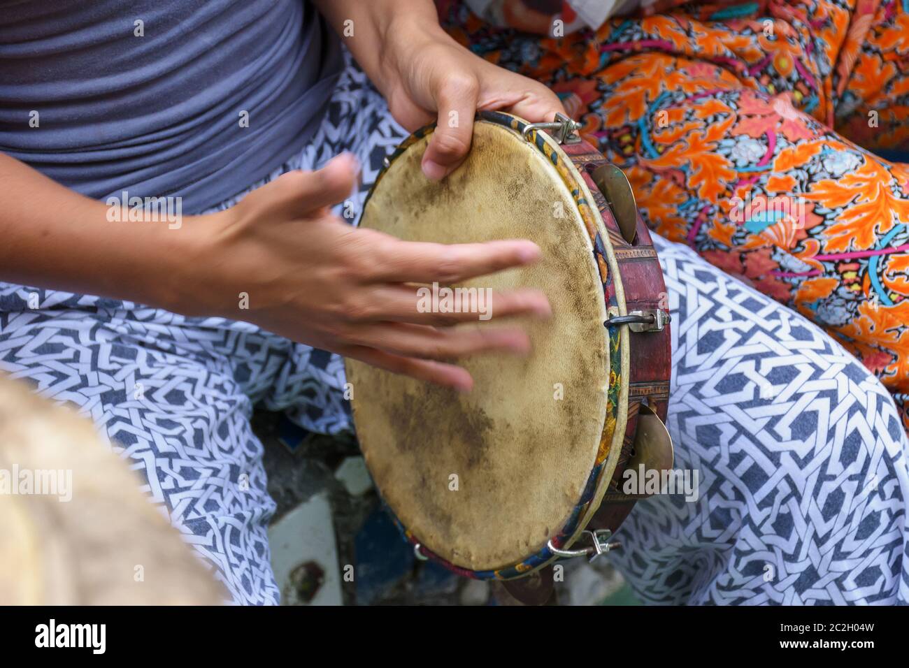 Mani della donna che giocano il tamburello Foto Stock