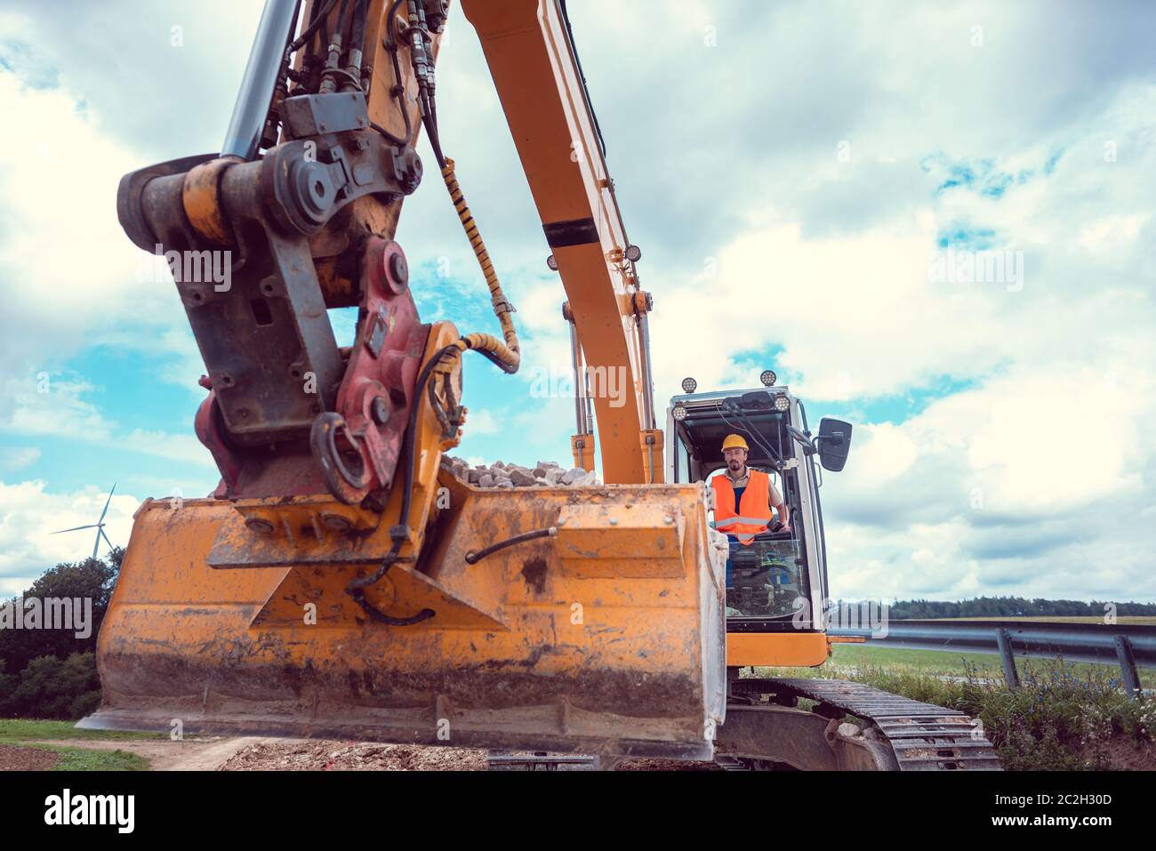 Operaio edile escavatore sulla pianificazione del lavoro da fare sul sito Foto Stock