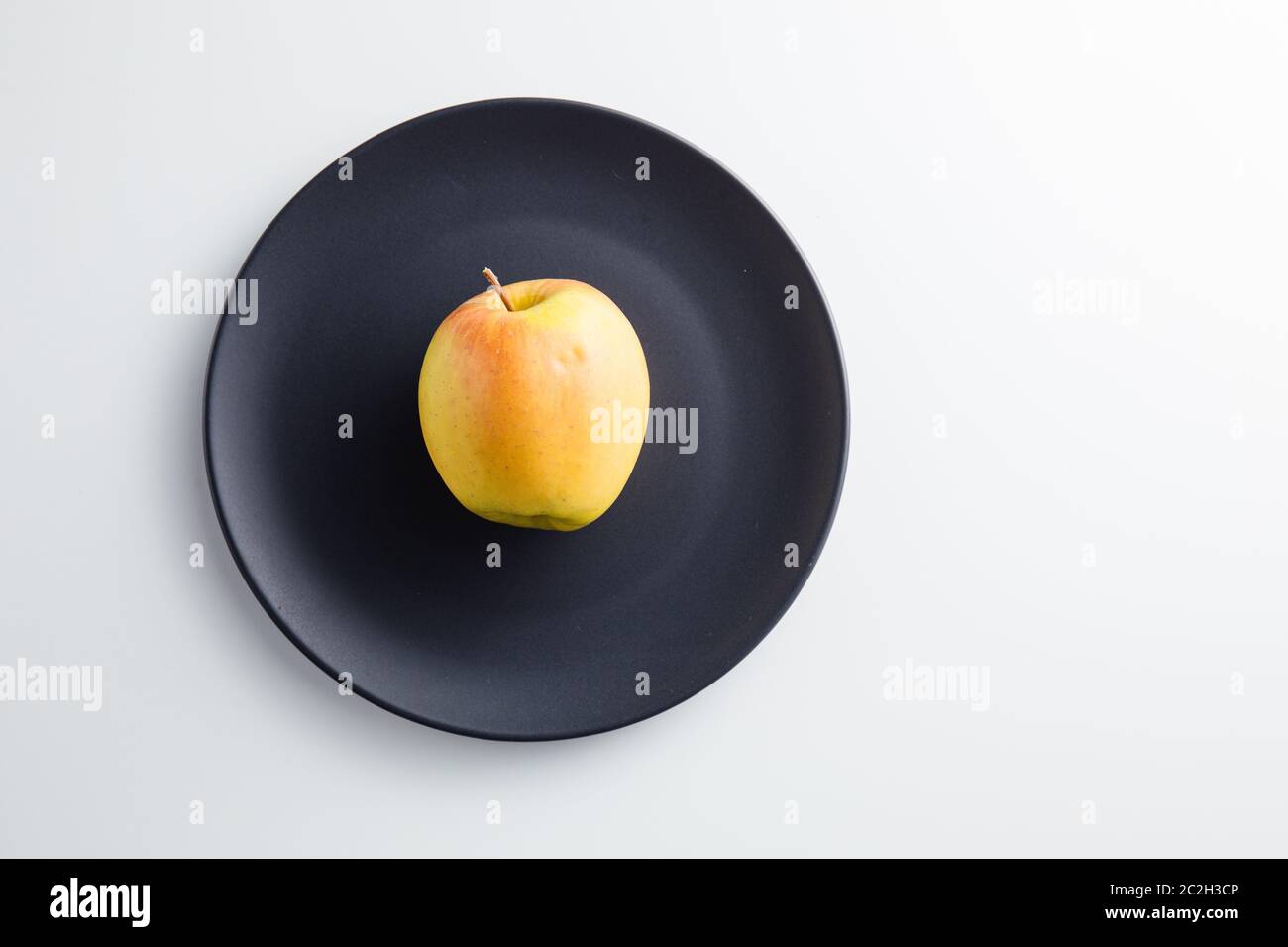 Primo piano di una Apple su un piatto Foto Stock