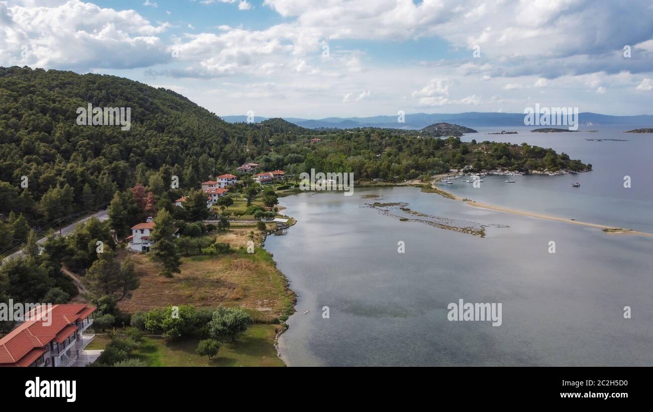 Mediterraneo greco paesaggio costiero drone shot. Vista aerea della penisola di Sithonia Chalkidiki sopra la costa con piantagione verde e case basse Foto Stock