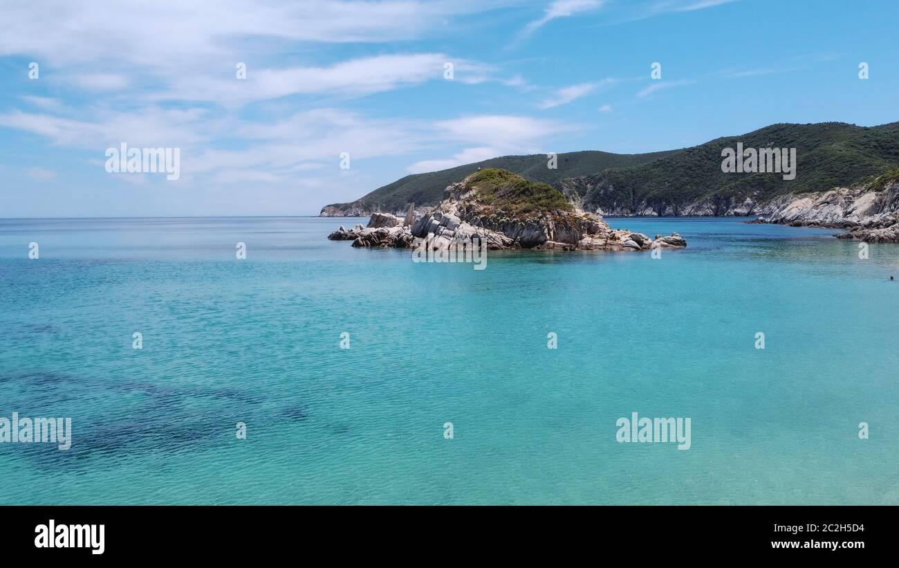 Mediterraneo greco paesaggio spiaggia drone shot. Vista aerea della penisola di Sithonia Chalkidiki sopra la costa rocciosa con piantagione verde e acque cristalline Foto Stock