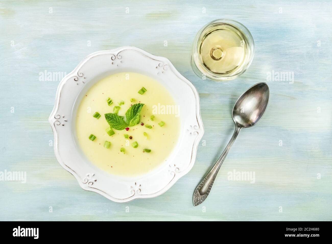 Vichyssoise, Francese zuppa fredda, girato dalla parte superiore con un bicchiere di vino bianco Foto Stock