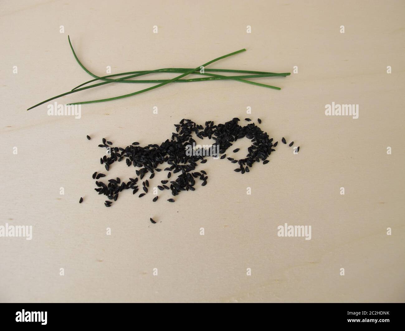 Semi di erba cipollina su una tavola di legno Foto Stock