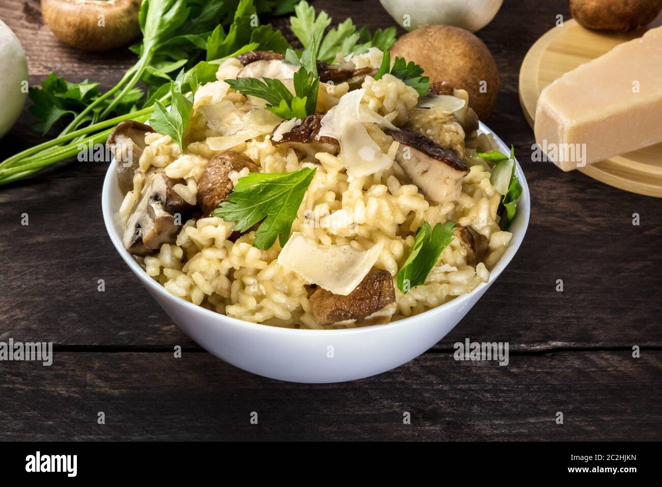 Risotto ai funghi, funghi Riso, con ingredienti al buio su un rustico sfondo di legno Foto Stock