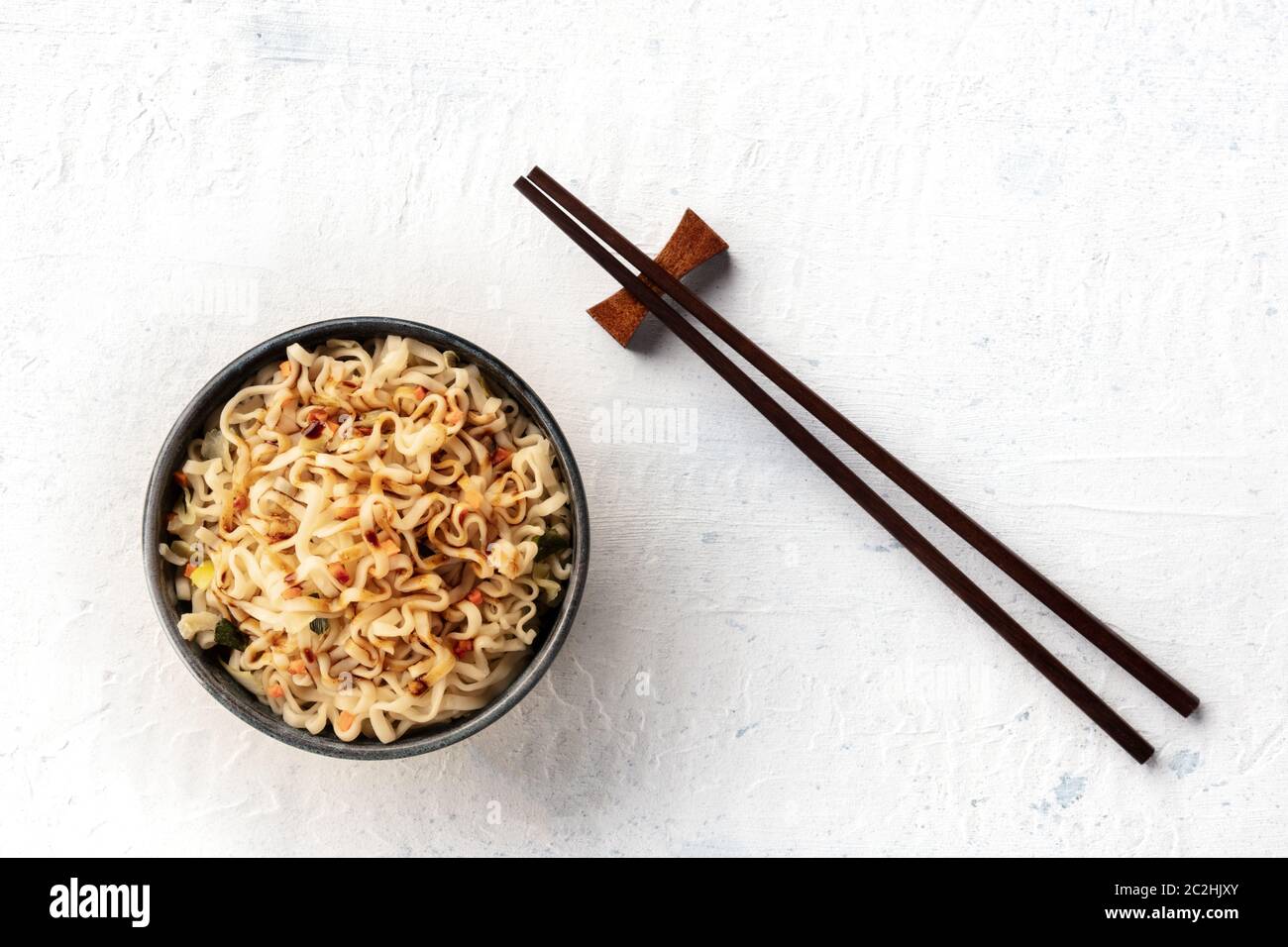 Instant Soba Noodles con scalliions, carota e una salsa scura, girato dalla parte superiore con bacchette e spazio di copia Foto Stock